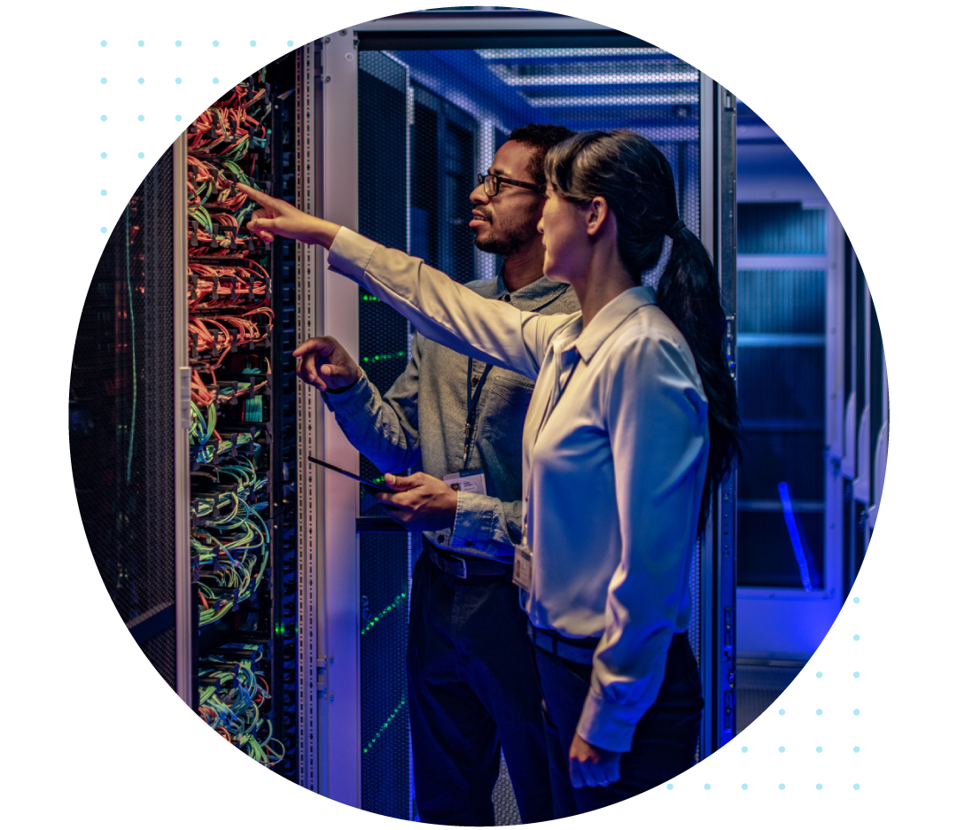 Man and woman pointing at cables in a server room.